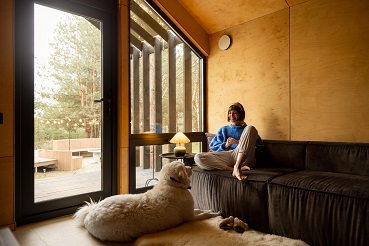 a woman sitting in a cabin with a white dog