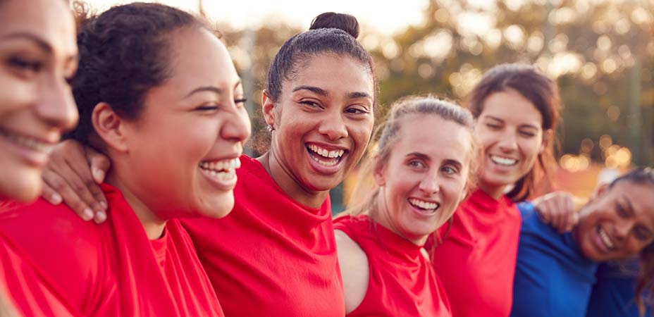 women smiling and holding each others shoulders